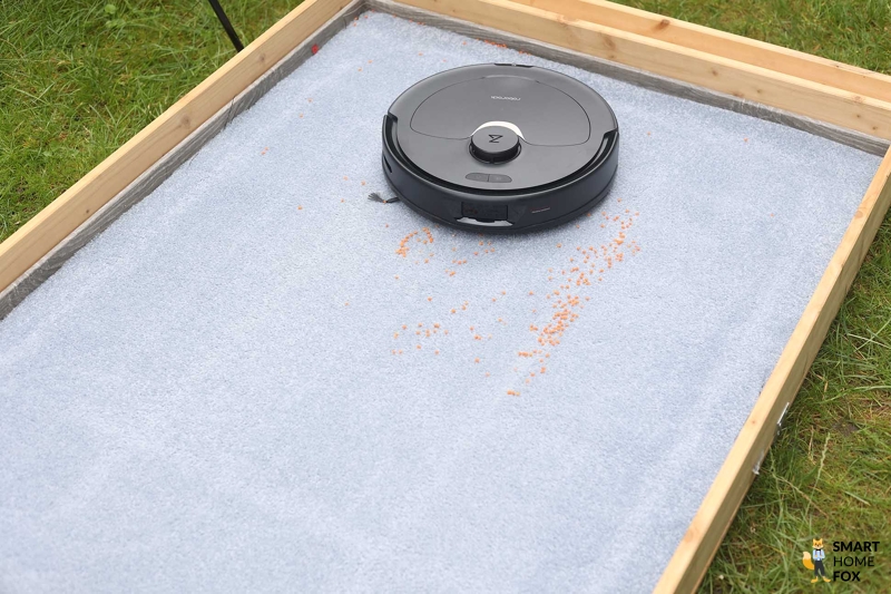 Der Roborock Q Revo beim Linsensaugtest auf einem hochflorigen Teppich.